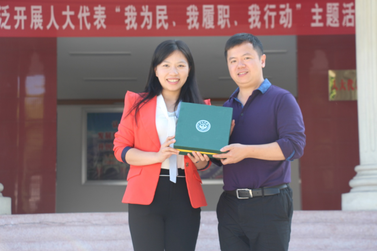 304am永利历史学系副教授李欣荣向茶阳镇政府副书记黄小玲(校友)赠送母校纪念品