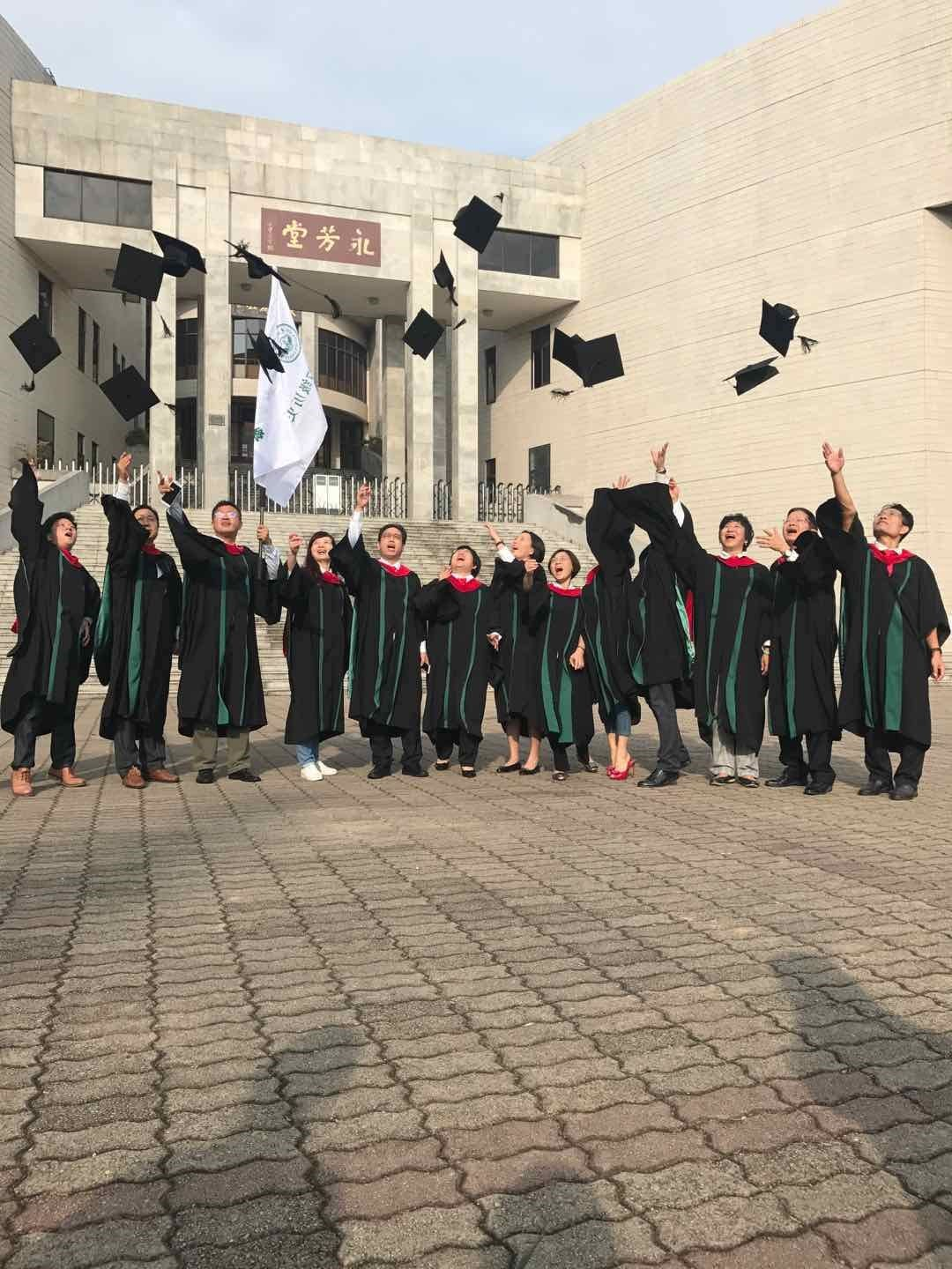(系友换上学士服后于永芳堂前合影)