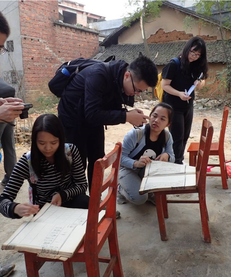 同学们在拍摄村民家的老族谱