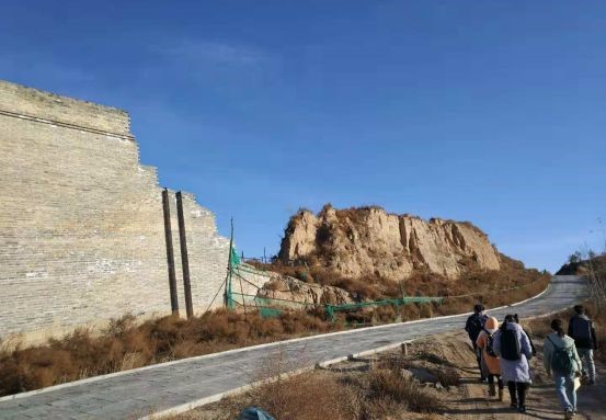 近处修缮中的城墙和远处的古城墙遗址